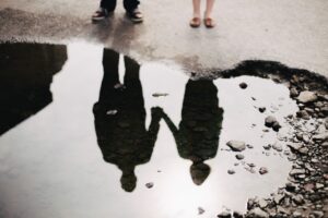 couple reflecting in a puddle